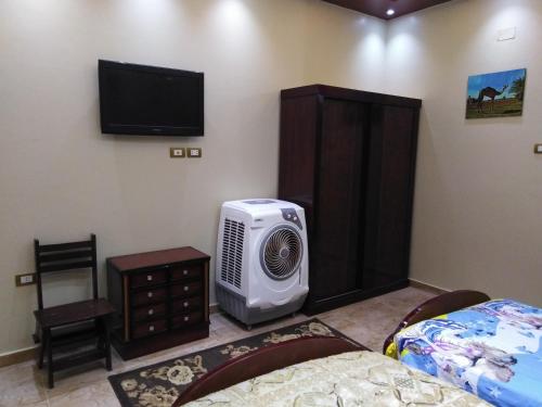 a room with a bed and a television and a room with a bed at Safari Abu Simbel in Abu Simbel