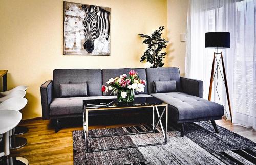 a living room with a couch and a table with flowers at Best Place Apartments Vienna in Vienna
