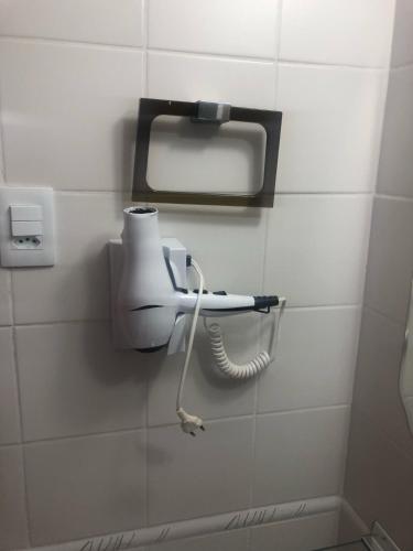 a bathroom with a hair dryer on a wall at Barra Summer flat in Salvador