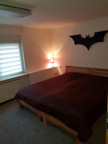 a bedroom with a bed with a bat sign on the wall at Ferienwohnung Bonndorf in Wasungen