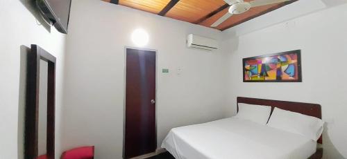 吉拉爾的住宿－Hotel Acapulco，卧室配有一张床,墙上挂有绘画作品