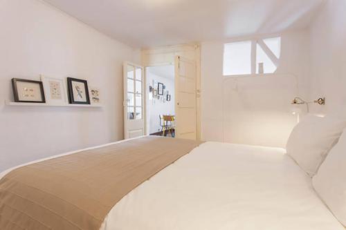 een slaapkamer met een groot wit bed en een raam bij Oak Valley Flats Bairro Alto in Lissabon