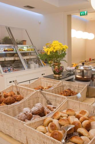 a bunch of trays of donuts on a counter at Hotel Sempione in Milan