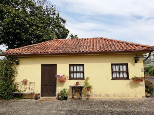 a small yellow house with a red roof at Quinta da Imaculada in Arcos de Valdevez