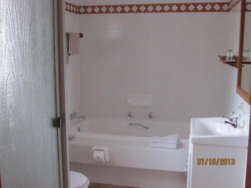 a bathroom with a tub and a toilet and a sink at Melkhoutkloof Guest House in Outeniqua Strand