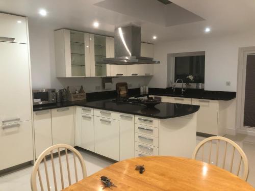 a kitchen with white cabinets and a wooden table at South Avenue B&B in Oxford
