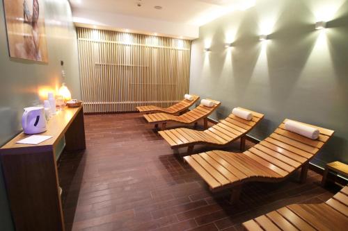 a waiting room with wooden chairs and a counter at Regiohotel Manfredi in Manfredonia