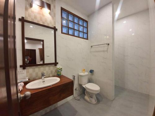 uma casa de banho com um lavatório, um WC e um espelho. em Villa Chitchareune 2 em Luang Prabang