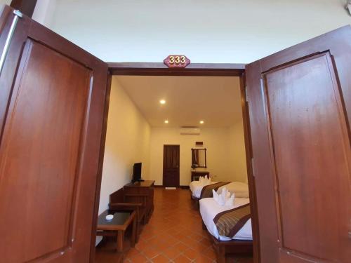 a room with two beds and a room with a mirror at Villa Chitchareune 2 in Luang Prabang