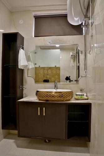 a bathroom with a sink and a large mirror at Marigold Inn- Homestay in Jaipur
