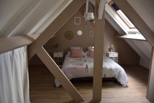 a bedroom with a bed in a attic at Le gite du Frene in Poses