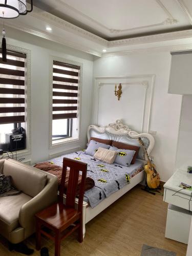 a bedroom with a bed and a chair and a couch at Khanh Phong Apartment PG02-20 in Hai Phong