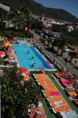 
a beach with a pool, chairs, tables and umbrellas at Ozturk Apart Hotel in Marmaris
