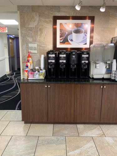 a counter with three coffee machines on top of it at La Quinta Inn by Wyndham Davenport & Conference Center in Davenport
