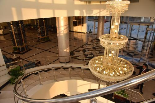 two chandeliers hanging from the ceiling of a building at Golden Jewel Beach&Hotel in Alexandria