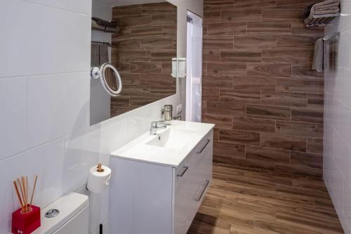 a bathroom with a white sink and a wooden wall at Loft del Mar 2 Jandia in Playa Jandia