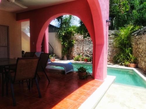 einen Hinterhof mit einem Pool und einem rosa Haus in der Unterkunft Casa Dell´acqua Merida in Mérida