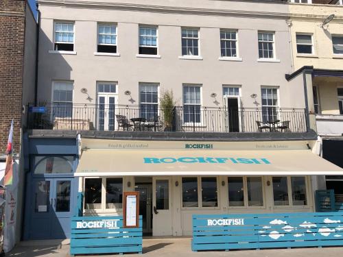 un edificio con toldo frente a un restaurante en Beachfront with balcony 1st Floor apartment "The Beaches" en Weymouth