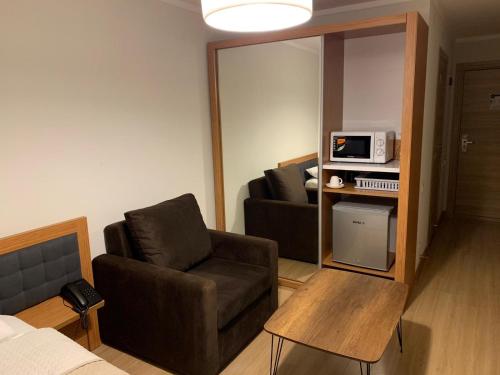 a living room with a couch and a chair and a microwave at ORBI PALACE DELUX Bakuriani room 470 in Bakuriani