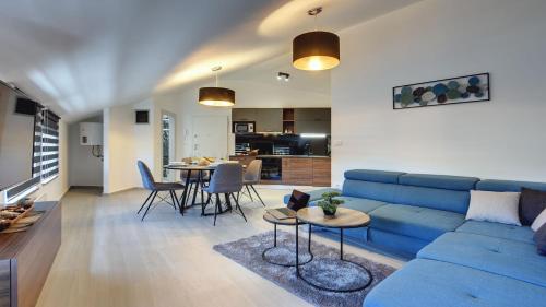 uma sala de estar com um sofá azul e uma mesa em Exclusive City Apartments em Pula