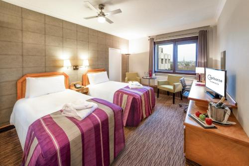 プリマスにあるコプソーン ホテル プリマスのベッド2台とテレビが備わるホテルルームです。