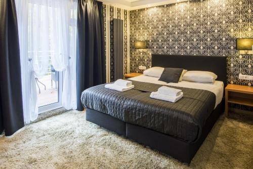 a bedroom with a bed with two towels on it at Villa Monte Dana in Zwanenburg