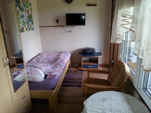 a bedroom with a bed and a chair and a window at Pod Sową in Drawsko Pomorskie