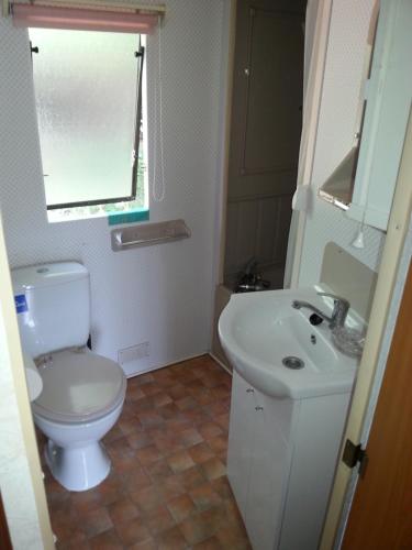 a bathroom with a white toilet and a sink at Pod Sową in Drawsko Pomorskie