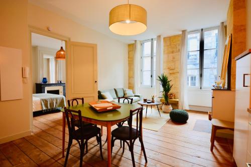 un salon avec une table et une chambre dans l'établissement Maison Bouquiere La Cabrerie, à Bordeaux