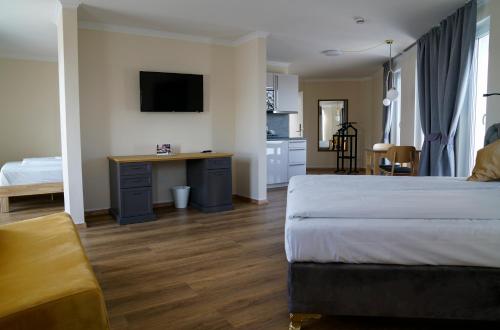 1 dormitorio con 1 cama y escritorio con TV en Boardinghouse City Home, en Bielefeld
