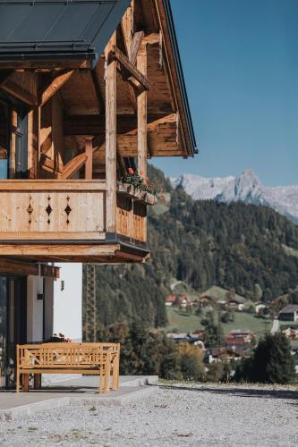 a wooden bench sitting in front of a building at Appartements Wieshof in Sankt Johann im Pongau