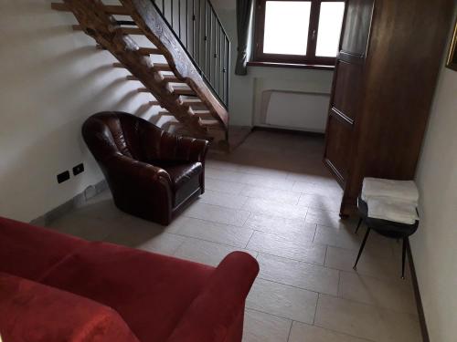 a living room with a couch and a chair at Agriturismo Il Balcone sulla Valle in Bedero Valcuvia