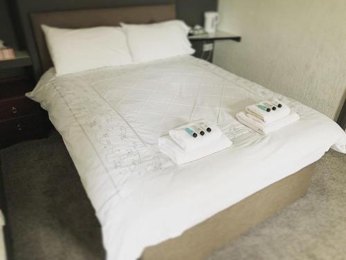 a white bed with two towels on top of it at Manchester Stay Hotel - Free Parking in Manchester
