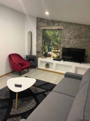 un soggiorno con un divano e una TV di Casa do Ribeiro Frio a Santana