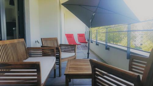 une chambre avec des chaises, des tables et un parasol dans l'établissement Les Picaillons - A 200m du lac, à Aix-les-Bains