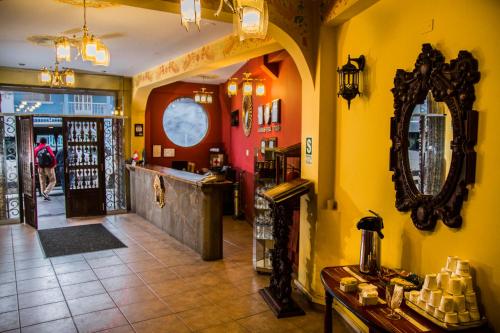 een restaurant met gele muren en een spiegel aan de muur bij Hotel Warari in Cuzco