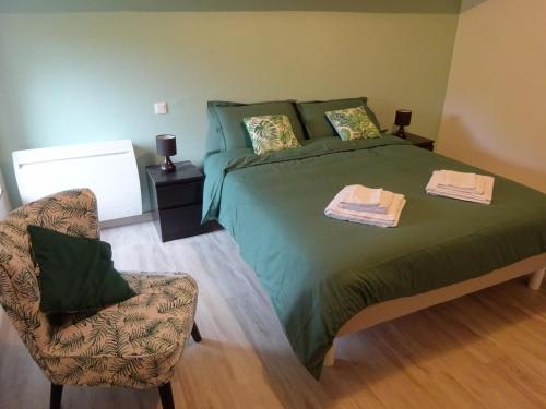 - une chambre avec un lit vert et une chaise dans l'établissement Le Cottage de Paul et Angéline, à Boismé