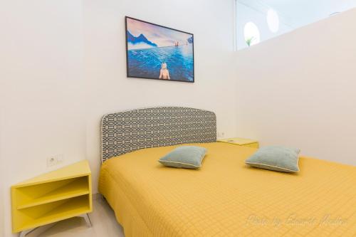 1 dormitorio con 1 cama amarilla y 2 almohadas en Casa Ricardo BEACH Apartment, en Morro del Jable