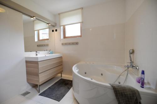 a white bathroom with a tub and a sink at Eva's house in Ivanec
