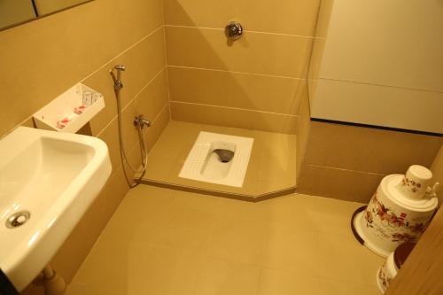 a small bathroom with a toilet and a sink at HOTEL MADNI ROYALE (50 Mtrs from Dargaah), Ajmer in Ajmer
