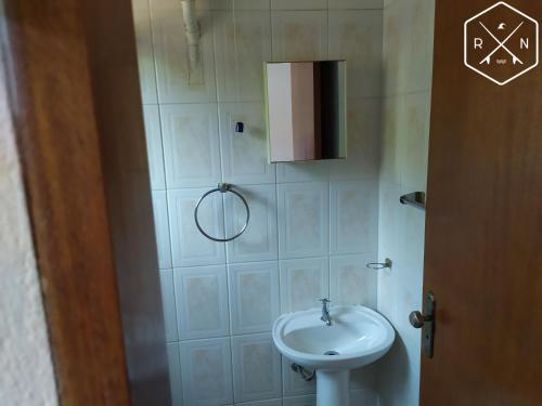 a small bathroom with a sink and a toilet at Recanto da Nina in Maresias