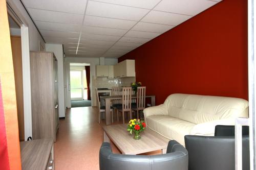 ein Wohnzimmer mit einem Sofa und einem Tisch in der Unterkunft Vakantie-Oord "De Hulsdonken" in Bergeijk