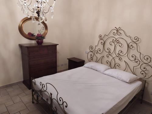 a bedroom with a bed and a mirror and a dresser at Astixio in San Damiano dʼAsti