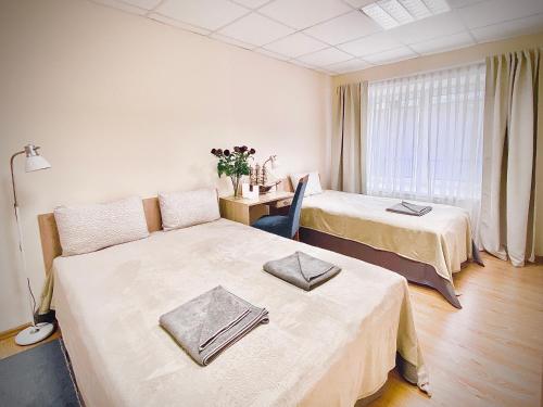 a hotel room with two beds and a desk at Jazz Time Studio in Birštonas