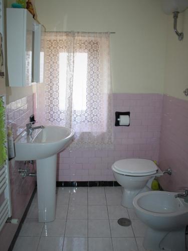 a pink bathroom with a sink and a toilet at Bed and Breakfast San Marco Pacentro in Pacentro