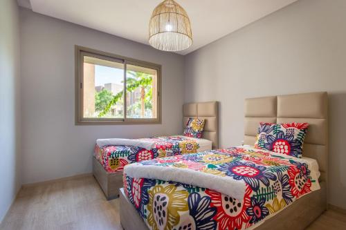 una camera con due letti e una finestra di Pool View With Garden in Prestigia - WIFI & Pool a Marrakech