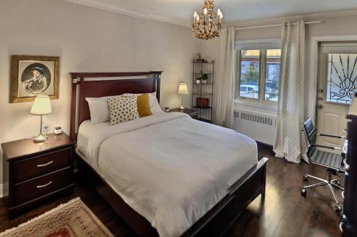 a bedroom with a large bed and a chandelier at Gite du Survenant Montreal in Montréal