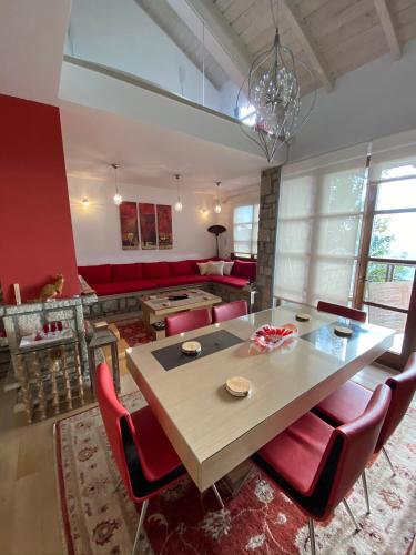 a dining room with a table and red chairs at Arachova Vip smart chalet-Villa Eva 1 in Arachova