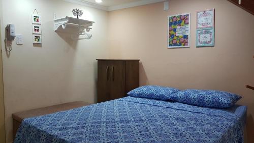 - une chambre avec un lit et une couette bleue dans l'établissement Estilo Residence II, à São Lourenço