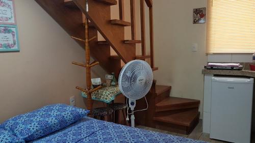 une chambre avec un ventilateur à côté d'un escalier dans l'établissement Estilo Residence II, à São Lourenço
